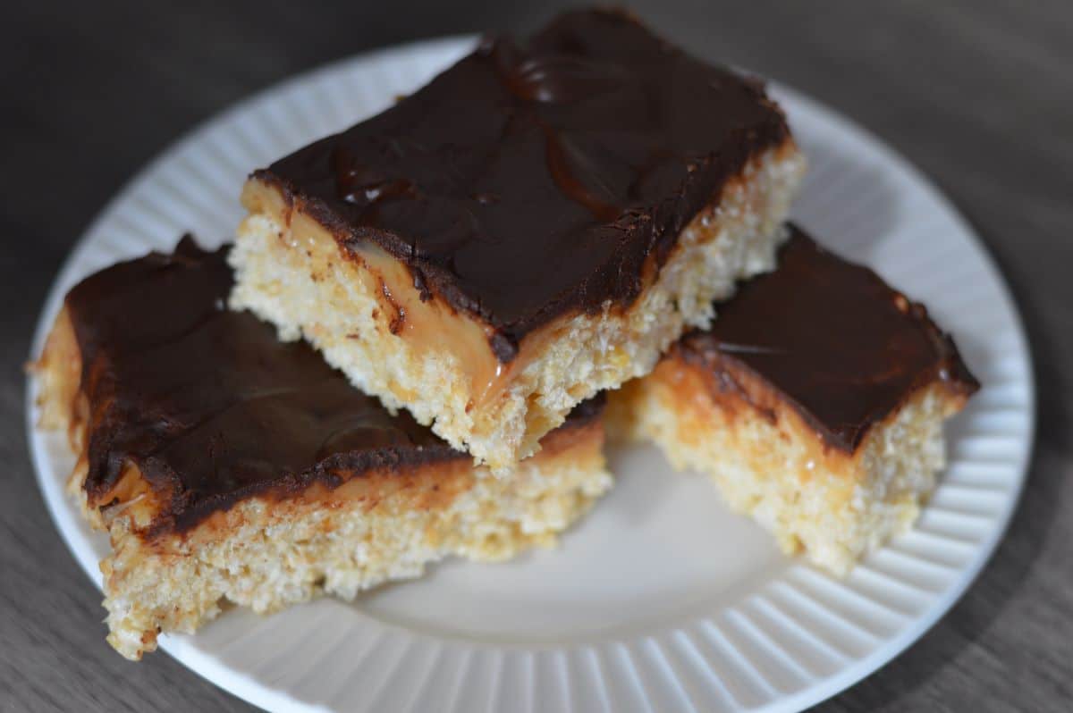 White platter that serves 3 Rice Krispie treats with a melty caramel middle and chocolate topping.